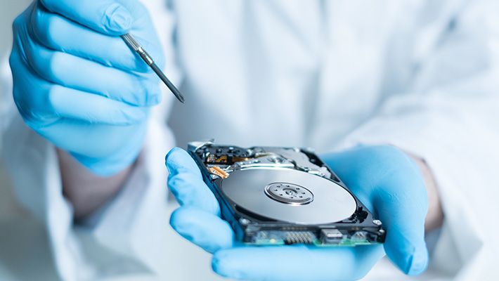 A lab technician holding a piece of hardware